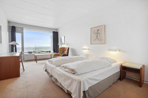 奥本罗Hotel Østersø的一间卧室设有两张床、一张桌子和一个窗口。