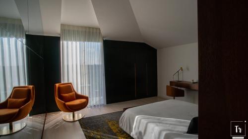 阿纳迪亚Quinta das Donas的酒店客房,配有一张床和两把椅子