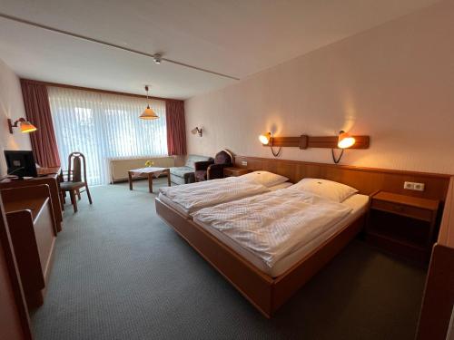于尔岑Hotel am Stern Uelzen的一间带大床的卧室和一间客厅