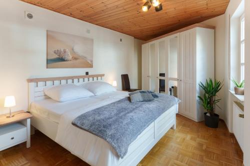 特里尔Casa Benedicta的卧室设有一张白色大床和木制天花板。
