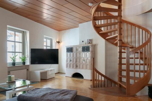 特里尔Casa Benedicta的一间带螺旋楼梯和电视的客厅