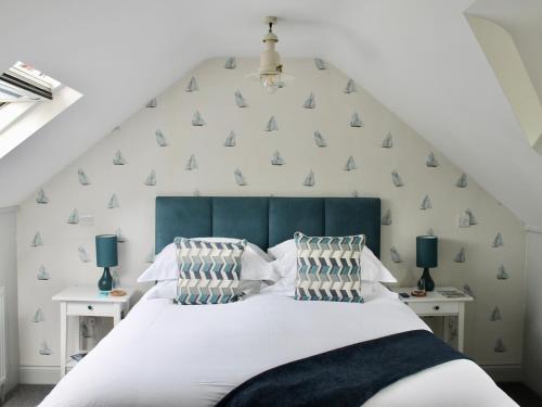 奇切斯特The Bosham Boathouse的一间卧室配有一张白色的床和蓝色床头板