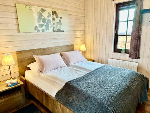博尔加内斯Klettur的卧室内的一张床铺,设有木墙