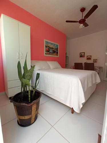 库亚巴Temporada Cuiabana的卧室配有白色的床和盆栽植物