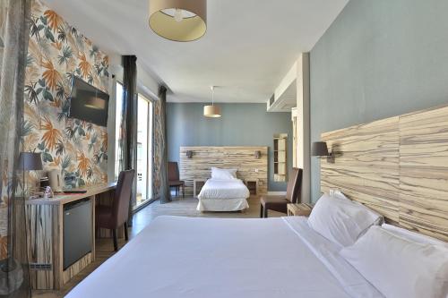 比亚里茨马贝拉布里特酒店的卧室配有一张白色大床和一张书桌