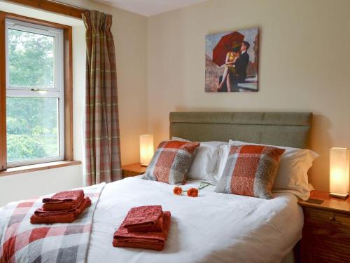 KiltarltyNursery Cottage - Beaufort Estate的一间卧室配有一张带红色毛巾的床