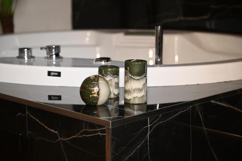 科森扎Palace Eight - Suites & Spa的两个花瓶坐在浴缸旁的架子上