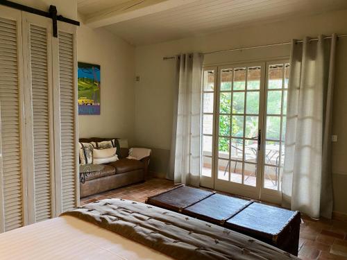 勒博塞La Bastide du Beausset-Vieux的一间卧室配有一张床、一张沙发和一个窗口
