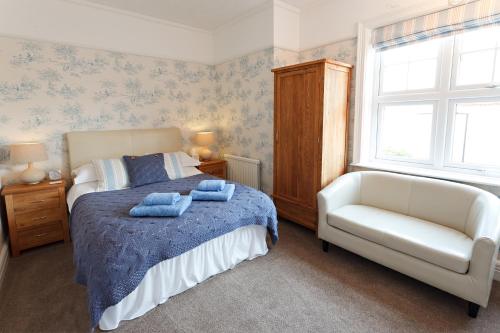 谢林汉姆Camberley House的卧室配有床、椅子和窗户。