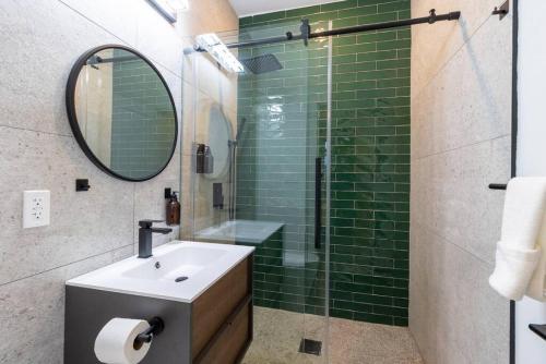 费城Thena Hotel- Lux Studio的浴室设有水槽和绿色瓷砖淋浴。