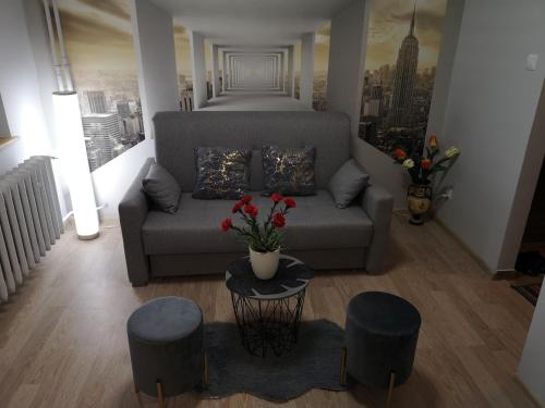 克罗斯诺Apartament przy dworcu的客厅配有沙发和2张凳子