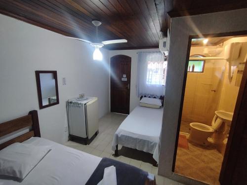 帕拉蒂Pousada Taquinha Paraty的小房间设有两张床和镜子