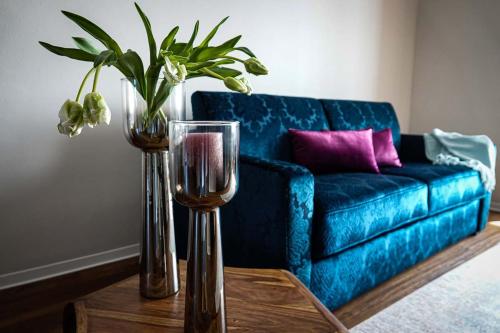 卢布明Residence Black Eagle Lubmin Strand的客厅配有蓝色的沙发和带玻璃杯的桌子