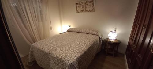 梅里那德奥拉菲APARTAMENTO EN CIUDAD EXPO的一间卧室配有一张床和一张桌子上的台灯