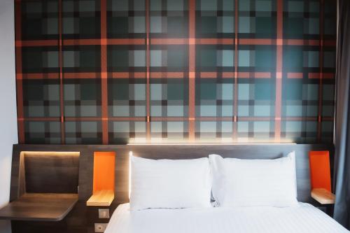 奥贝维利埃easyHotel Paris Nord Aubervilliers的一张带两个白色枕头和墙壁的床