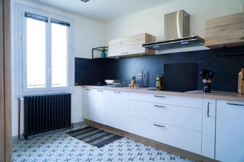 沙托鲁Le Straw' Berry • Fibre • Calme的厨房配有白色橱柜和窗户。