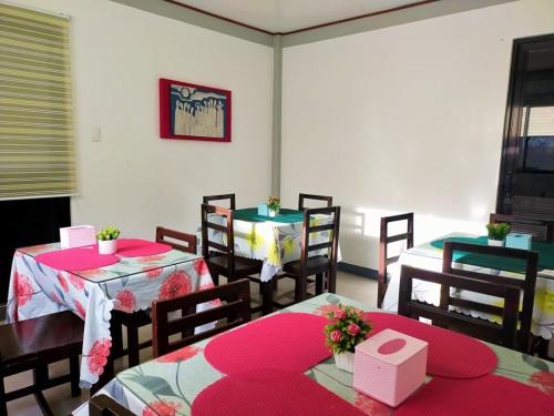拉瓦格E & C Hotel的用餐室配有2张带粉红色垫的桌椅