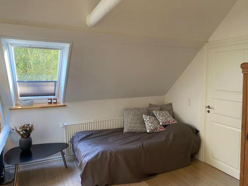 瓦埃勒Naturskøn landidyl på Ibækgaarden - I egen bolig的一间卧室配有一张床、一张桌子和一个窗户。