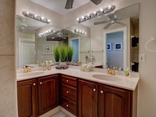 珊瑚角Villa Cosima的一间带两个盥洗盆和大镜子的浴室