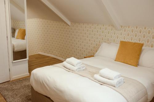 菲什加德JT Abergwaun hotel的卧室配有带毛巾的大型白色床