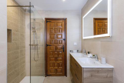 MontgoCasa Cora的带淋浴、盥洗盆和镜子的浴室