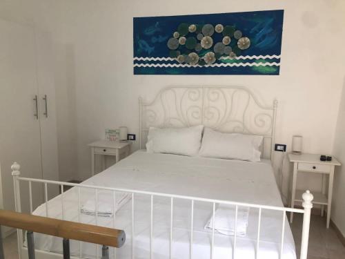 里奥马哲雷Rio Rest Apartments的卧室配有一张白色床,墙上挂有绘画作品