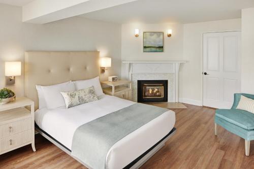 太平洋丛林翠绿庄园旅馆，四姐妹旅馆的卧室配有白色的床和壁炉