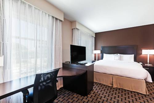 奥斯汀Residence Inn by Marriott Austin Northwest/The Domain Area的酒店客房配有一张床和一张书桌及一台电视