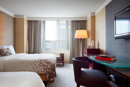 哥伦布哥伦布市中心万丽酒店的酒店客房配有一张床、一张书桌和一台电视。