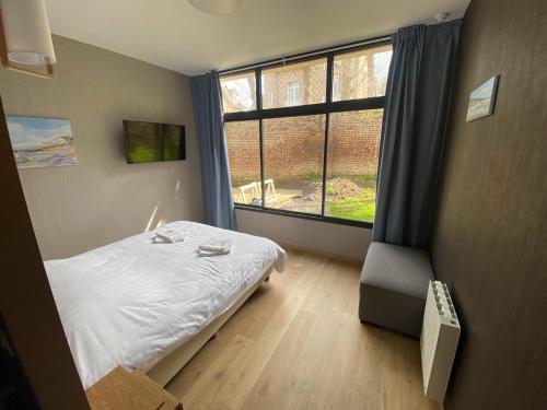 迪耶普Parc Beausejour Aparthotel的一间卧室设有一张床和一个大窗户