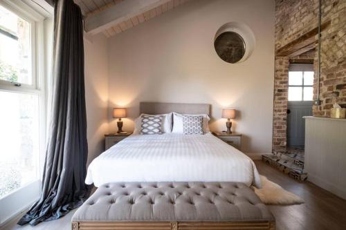 卡斯尔贝灵汉The Mews -- Luxury Stay at Bellingham Estate的一间卧室设有一张大床和两个窗户。