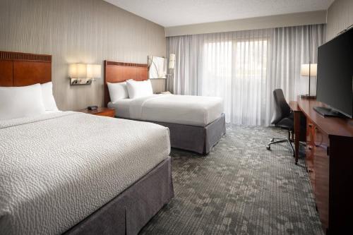 梅萨Courtyard by Marriott Phoenix Mesa的酒店客房设有两张床和一台平面电视。