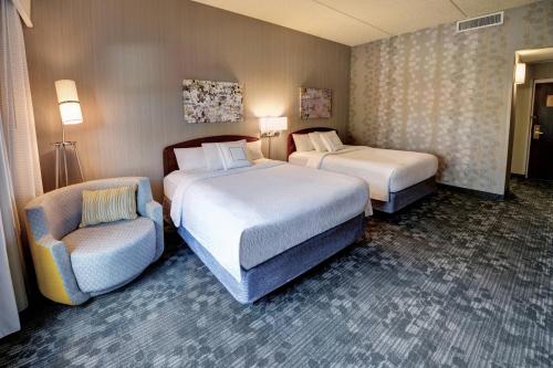 沃索沃索万怡酒店的酒店客房,配有两张床和椅子
