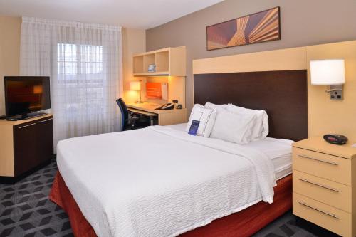 拉斯维加斯拉斯维加斯亨德森万豪广场套房酒店的酒店客房设有一张白色大床和一张书桌
