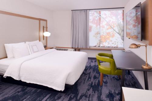 贝克斯菲尔德Fairfield Inn and Suites by Marriott Bakersfield Central的配有一张床、一张书桌和一扇窗户的酒店客房