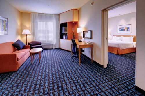 Weston万豪沃沙费尔菲尔德套房酒店的酒店客房配有一张床、一张沙发和一张书桌。