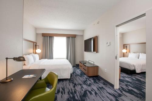 纽波特Fairfield by Marriott Inn & Suites Newport Cincinnati的酒店客房配有两张床和一张书桌