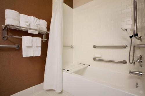 沃思堡沃斯堡大学路费尔菲尔德套房酒店的浴室配有浴缸、淋浴和毛巾。