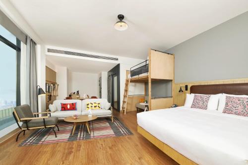 南京Moxy Nanjing Jiangning的一间卧室设有一张床和一间客厅。