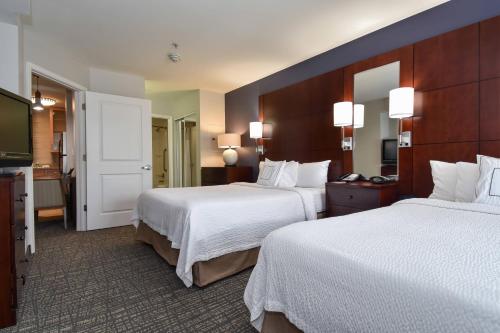 康科德夏洛特克恩克尔德原住酒店的酒店客房设有两张床和电视。