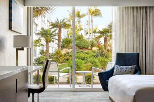 文图拉万豪文图拉海滩酒店的酒店客房设有床和棕榈树阳台