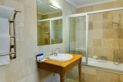 斯泰伦博斯Protea Hotel by Marriott Dorpshuis & Spa Stellenbosch的一间带水槽和淋浴的浴室