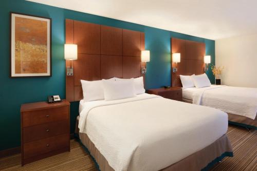 俾斯麦俾斯麦北原住客栈的酒店客房,设有两张床和蓝色的墙壁