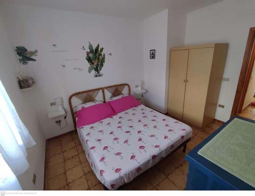 圣特奥多罗Casa Flamingo House的一间小卧室,配有一张带粉红色枕头的床