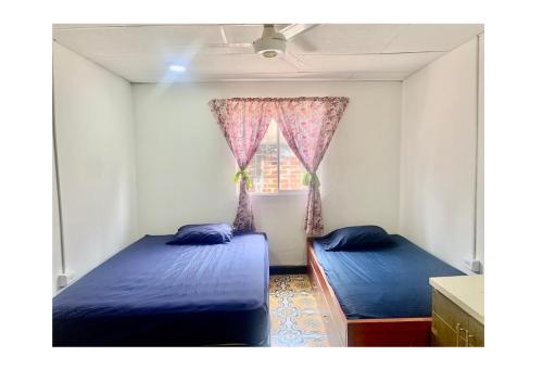 卡塔赫纳Casa Cairo的一间卧室设有两张床和窗户。