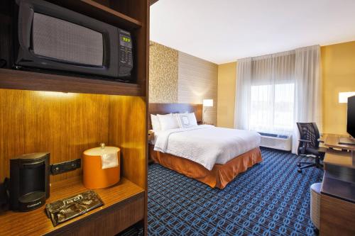 普拉茨堡Fairfield Inn & Suites by Marriott Plattsburgh的配有一张床和一台平面电视的酒店客房