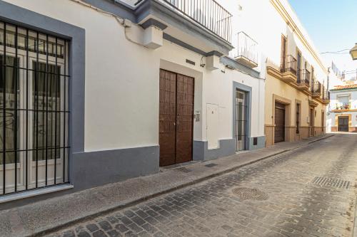 赫雷斯-德拉弗龙特拉Top & Chic Albarizuela Suites - Apartamentos Jerez的一条有建筑物的小巷里的鹅卵石街道