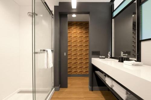 拉伯克Aloft Lubbock的浴室配有带起落水槽和淋浴。