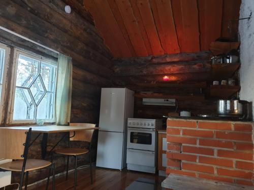 伊纳利Log Cabin - Lord of Sormuset的厨房配有冰箱、桌子和砖墙