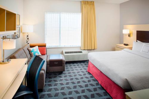 嘉年TownePlace Suites by Marriott Phoenix Goodyear的酒店的客房 - 带一张床、椅子和窗户